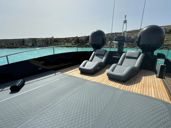 Thyke III Yacht Photos Pics Luxurious 2008 Pershing 90 yacht deck with sun loungers and scenic ocean view.