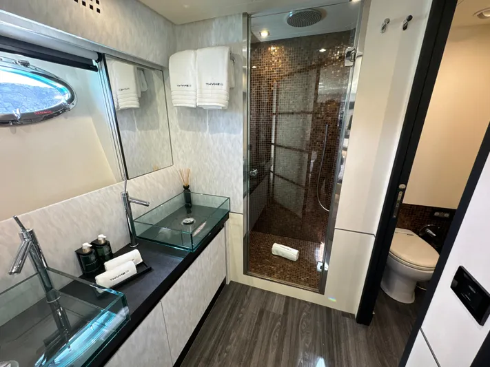Thyke III Yacht Photos Pics Luxurious bathroom on a 2008 Pershing 90 yacht with glass sinks and modern shower.