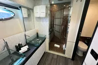 Luxurious bathroom on a 2008 Pershing 90 yacht with glass sinks and modern shower.