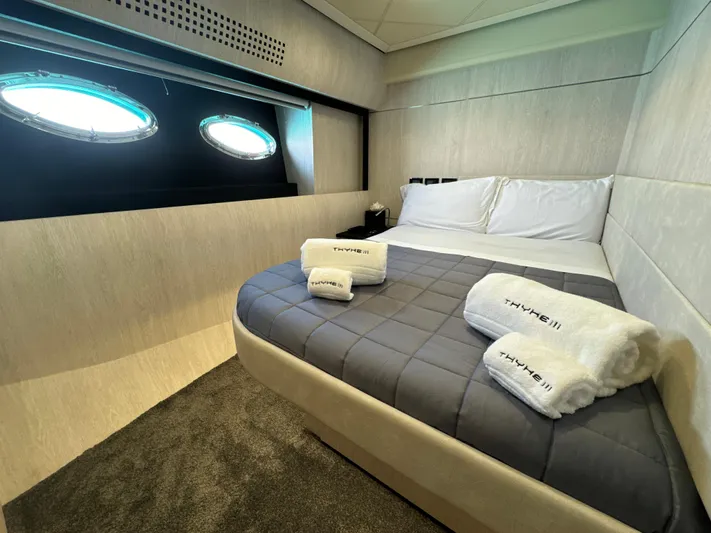 Thyke III Yacht Photos Pics Luxurious bedroom interior of 2008 Pershing 90 yacht with porthole windows and plush bedding.