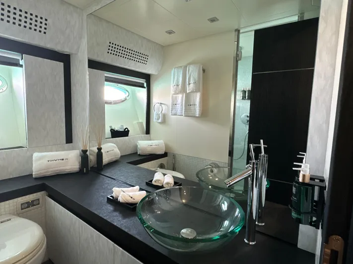 Thyke III Yacht Photos Pics Luxurious bathroom in 2008 Pershing 90 yacht with modern glass sink and elegant decor.