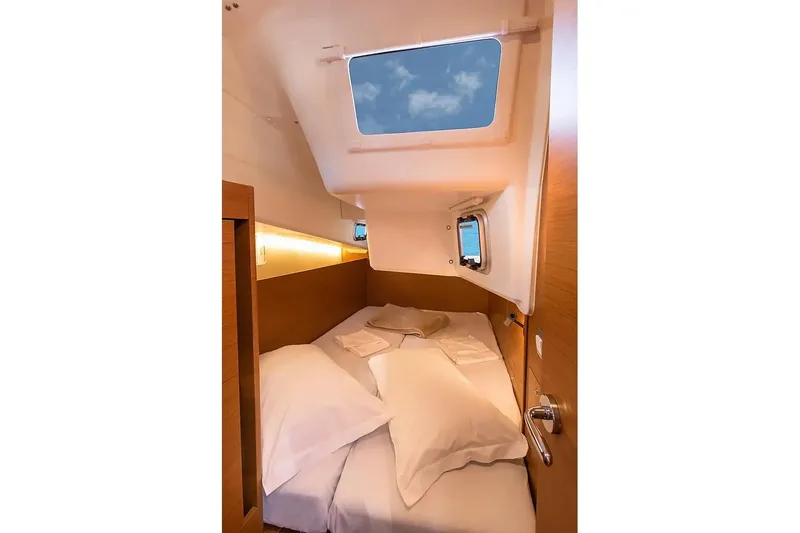  Yacht Photos Pics Cozy cabin interior of 2021 Jeanneau Sun Odyssey 410 sailboat with skylight and bedding.