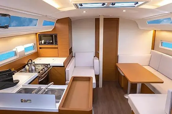  Yacht Photos Pics Interior of 2021 Jeanneau Sun Odyssey 410 yacht, featuring modern kitchen and seating area.
