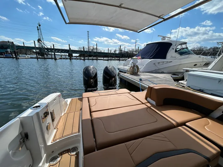  Yacht Photos Pics 2023 Chaparral 300 OSX boat docked, featuring spacious seating and dual engines.