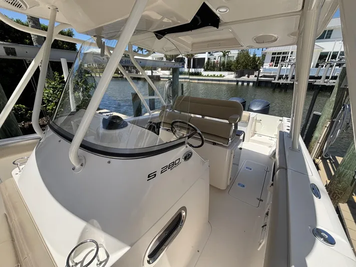  Yacht Photos Pics 2015 Pursuit S 280 Sport boat interior with helm, seating, and waterfront view.