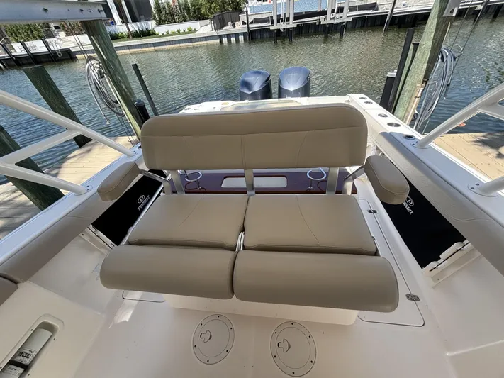  Yacht Photos Pics 2015 Pursuit S 280 Sport boat with beige seating, docked by the water.