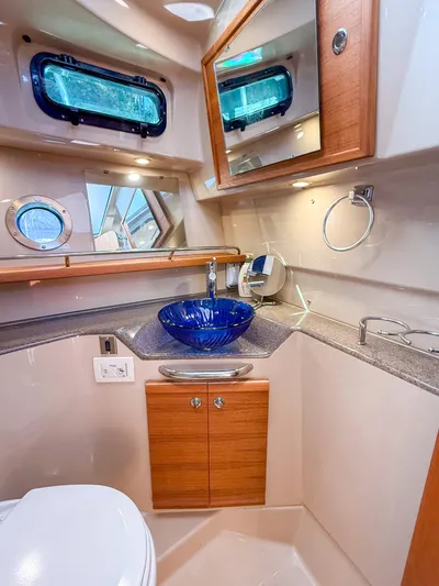  Yacht Photos Pics 2018 Ranger Tugs R-29 S bathroom with blue glass sink and wooden cabinetry.