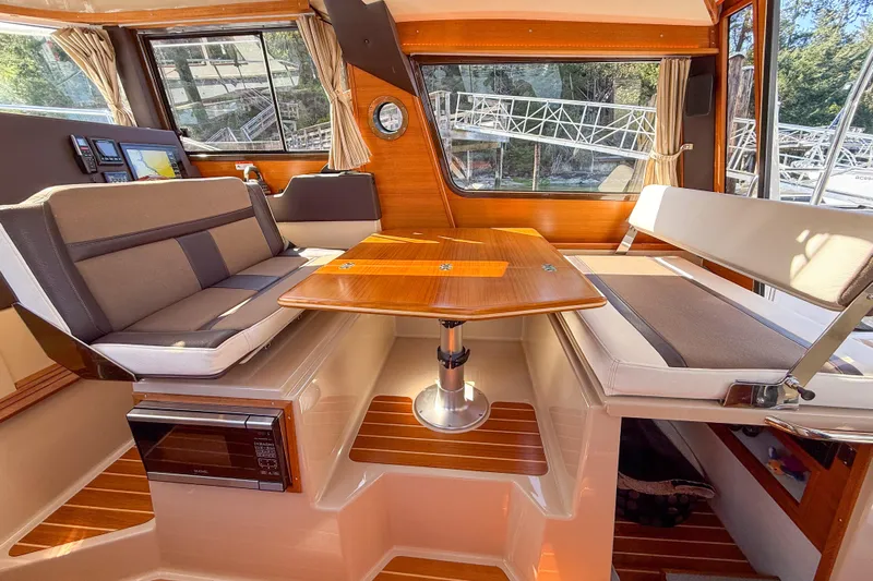  Yacht Photos Pics Interior of 2018 Ranger Tugs R-29 S with seating and wooden table.