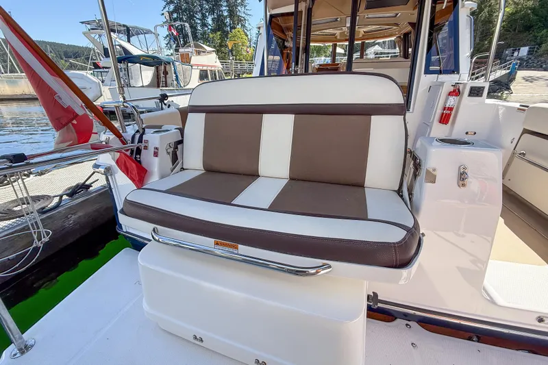  Yacht Photos Pics 2018 Ranger Tugs R-29 S boat with cushioned seating at the stern, docked at a marina.