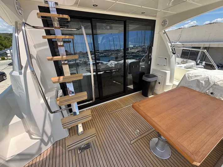  Yacht Photos Pics Luxury Jeanneau Prestige 460 yacht deck with wooden table and modern staircase, 2020 model.