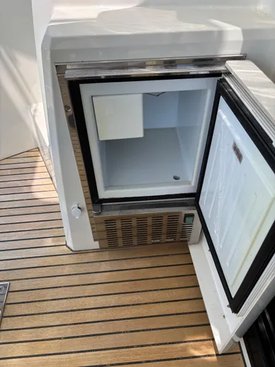  Yacht Photos Pics Open mini fridge on Jeanneau Prestige 460 yacht, 2020 model, with wooden deck flooring.