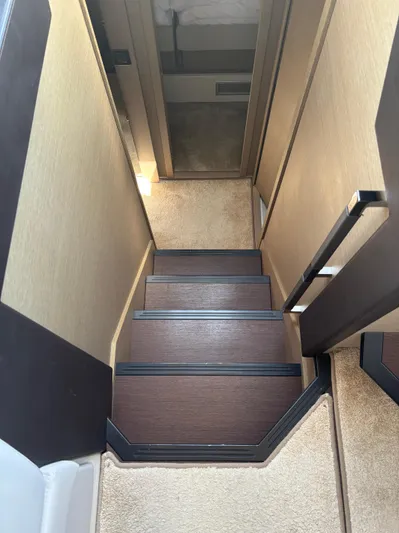  Yacht Photos Pics Staircase inside 2020 Jeanneau Prestige 460 yacht, featuring elegant wood and carpet design.