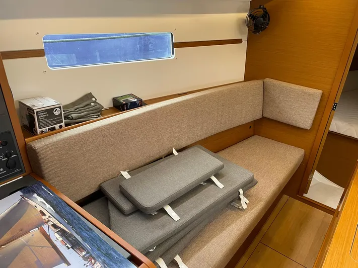  Yacht Photos Pics Interior of 2023 Jeanneau Sun Odyssey 349 sailboat with beige seating and cushions.