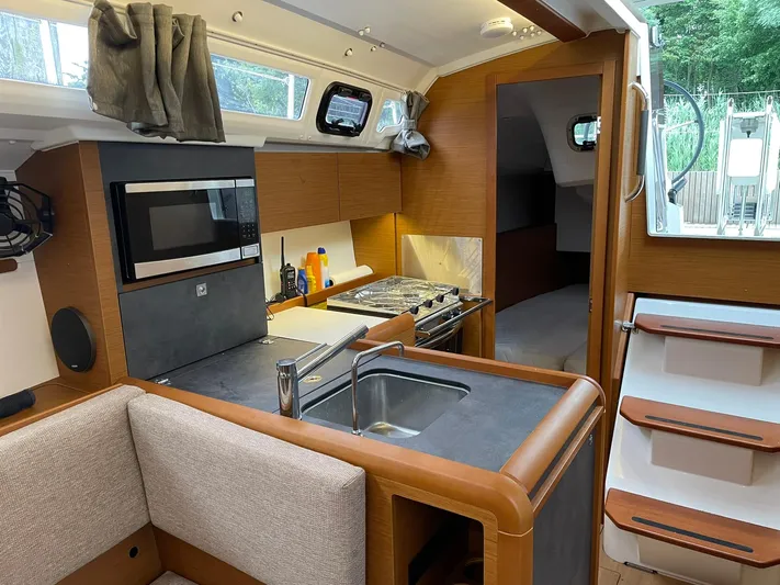  Yacht Photos Pics 2023 Jeanneau Sun Odyssey 349 interior with modern kitchen and cozy seating area.