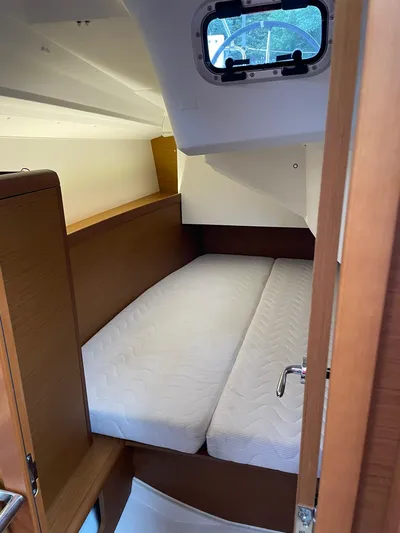  Yacht Photos Pics 2023 Jeanneau Sun Odyssey 349 cabin interior with bed and porthole window.