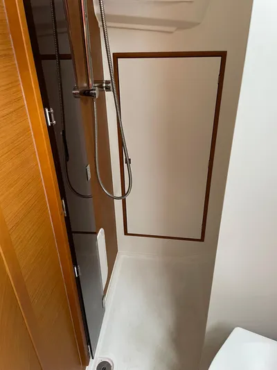  Yacht Photos Pics 2023 Jeanneau Sun Odyssey 349 shower area with modern fixtures and wooden accents.