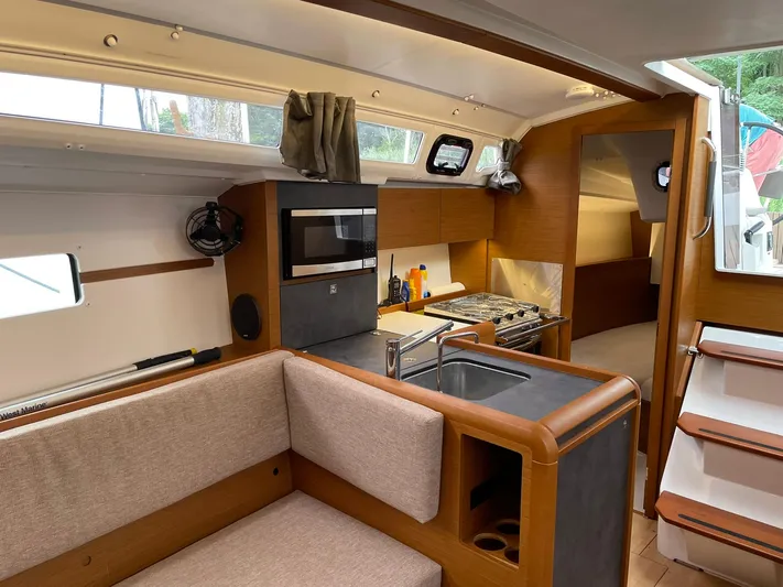  Yacht Photos Pics Interior of 2023 Jeanneau Sun Odyssey 349 sailboat, featuring a modern kitchen and seating area.
