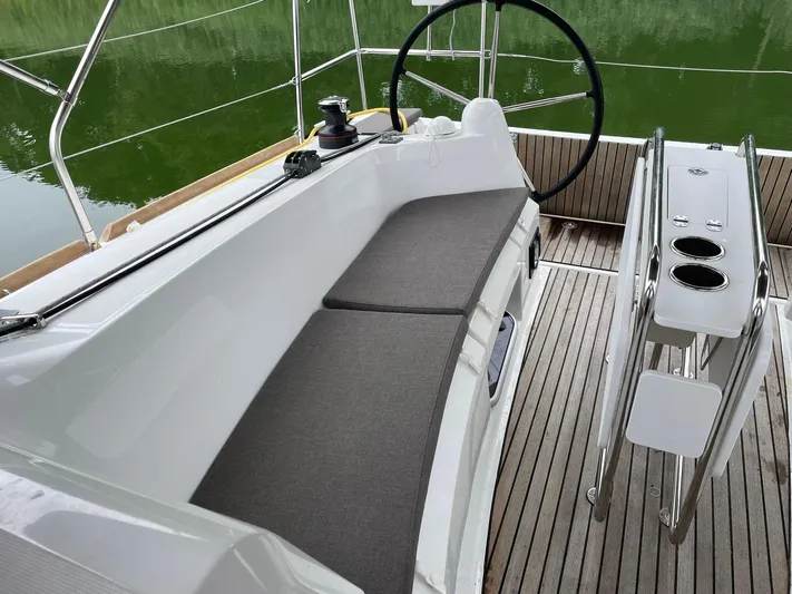 Yacht Photos Pics 2023 Jeanneau Sun Odyssey 349 cockpit with cushioned seating and steering wheel.