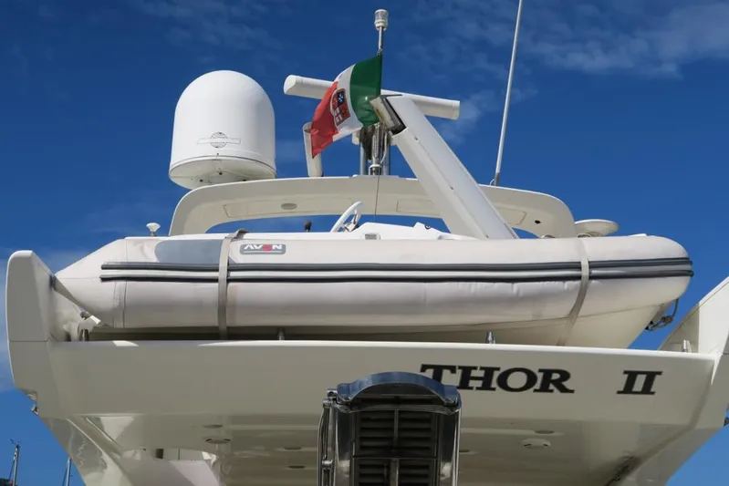  Yacht Photos Pics 2004 Azimut 55 yacht with dinghy and flag, named "Thor II," under clear blue sky.