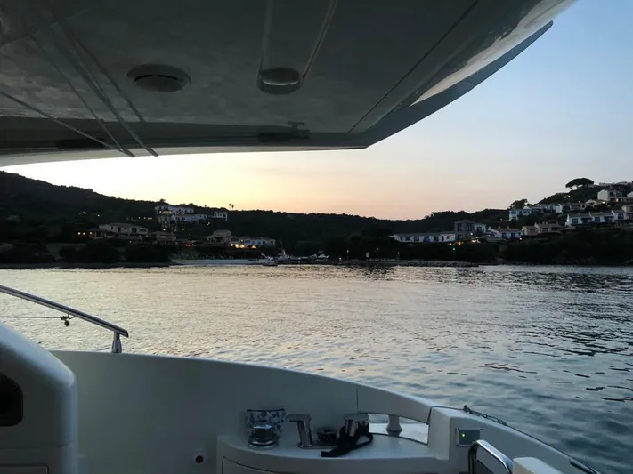  Yacht Photos Pics 2004 Azimut 55 yacht at sunset, overlooking serene coastal village.