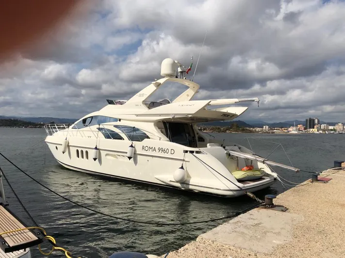  Yacht Photos Pics 2004 Azimut 55 yacht docked at a marina under cloudy skies.