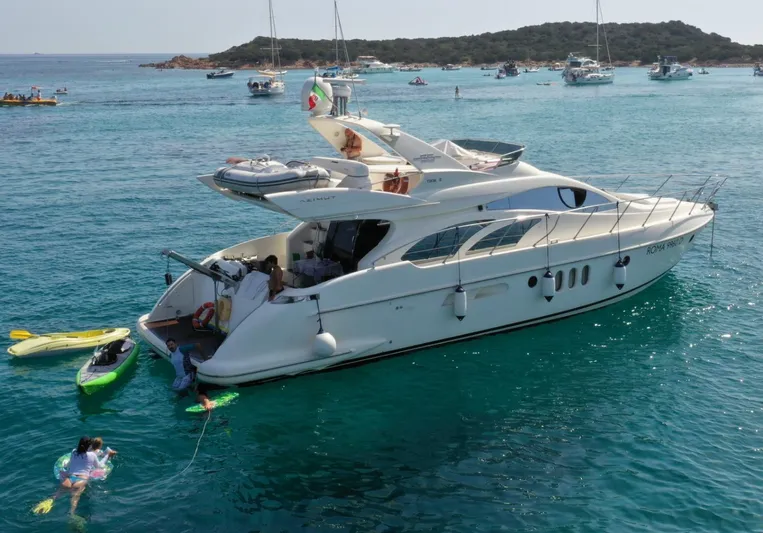  Yacht Photos Pics Luxury 2004 Azimut 55 yacht anchored in clear blue waters with kayaks nearby.