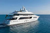 Luxury 2006 Burger Trideck yacht cruising on open sea under clear blue sky.