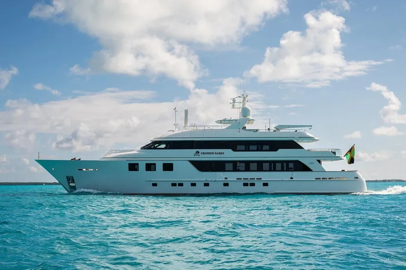 Crossed Sabre Yacht Photos Pics Luxurious 2006 Burger Trideck yacht cruising on clear blue ocean waters.