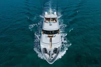 Luxury yacht Burger Trideck 2006 cruising on clear blue ocean waters.