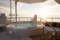 Luxurious 2006 Burger Trideck yacht with jacuzzi and sunset ocean view.