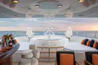 Luxurious 2006 Burger Trideck yacht deck with jacuzzi, bar, and ocean view at sunset.