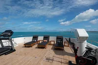 Luxurious 2006 Burger Trideck yacht deck with loungers, exercise equipment, and ocean view.