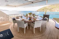 Luxurious dining setup on 2006 Burger Trideck yacht with ocean view.