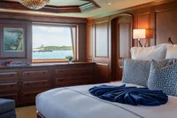 Luxurious yacht bedroom with ocean view, elegant wood paneling, and stylish decor on a 2006 Burger Trideck.