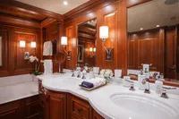 Luxurious yacht bathroom with wooden paneling, dual sinks, and elegant lighting, 2006 Burger Trideck.