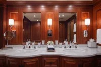 Luxurious yacht bathroom with dual sinks, elegant wood paneling, and modern fixtures on a 2006 Burger Trideck.