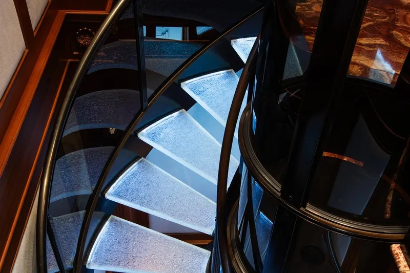 Crossed Sabre Yacht Photos Pics Illuminated spiral staircase on 2006 Burger Trideck yacht, featuring sleek design and modern aesthetics.