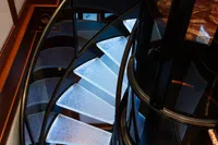 Illuminated spiral staircase on 2006 Burger Trideck yacht, featuring sleek design and modern aesthetics.