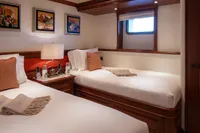 Luxurious twin cabin on 2006 Burger Trideck yacht with elegant decor and cozy bedding.