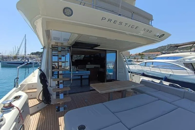  Yacht Photos Pics Luxury 2020 Prestige 590 yacht docked, featuring spacious deck and modern amenities.