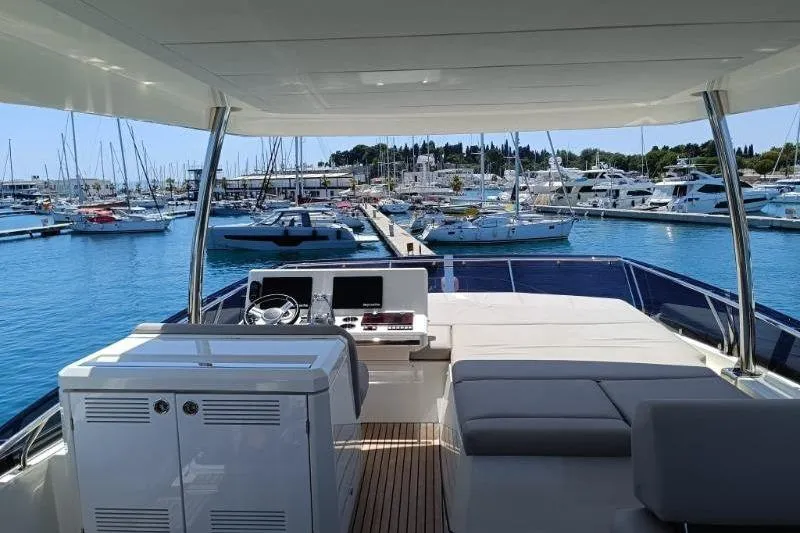  Yacht Photos Pics 2020 Prestige 590 yacht interior with marina view, featuring helm and seating area.