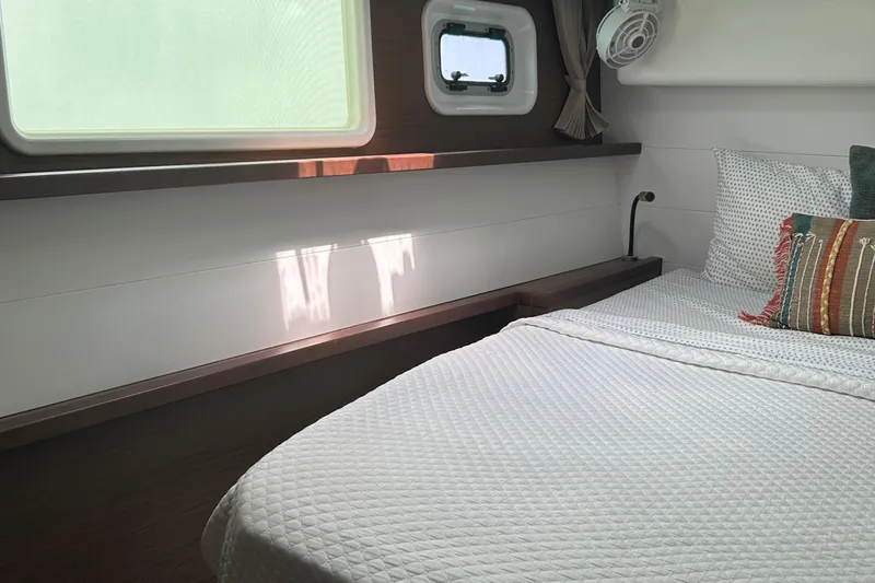 Habzie Yacht Photos Pics Cozy bedroom in 2019 Lagoon 450 F Owner's Edition yacht with window and bedding.