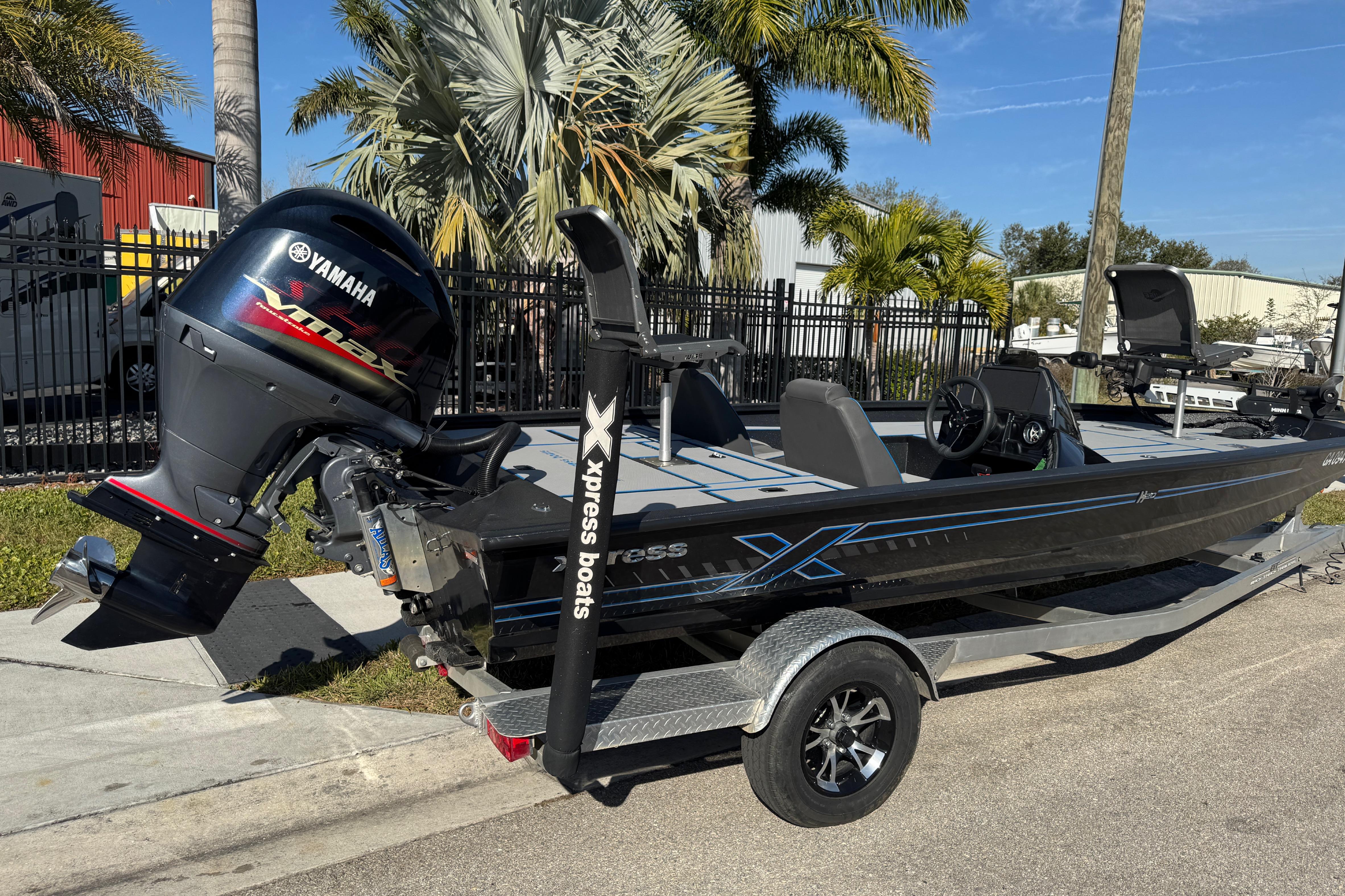 2025 Express H20 boat with Yamaha VMAX engine, parked on a trailer near palm trees.