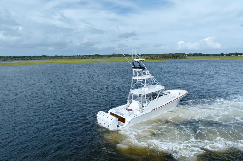 Front Runner Boatworks 47 Walkaround Yacht Photos Pics 2026 Front Runner 47WA boat cruising on a calm lake under a cloudy sky.