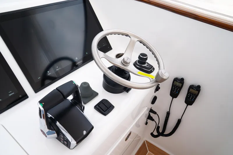 Front Runner Boatworks 47 Walkaround Yacht Photos Pics Control panel of 2026 Front Runner 47WA boat with steering wheel and navigation screens.