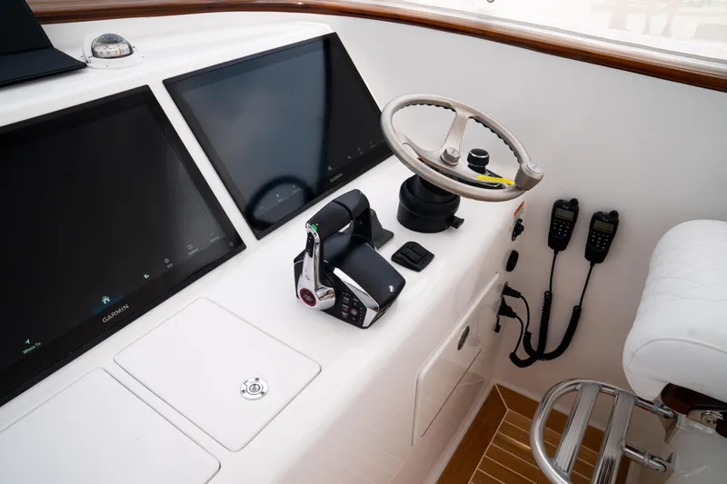 Front Runner Boatworks 47 Walkaround Yacht Photos Pics 2026 Front Runner 47WA boat helm with dual screens, steering wheel, and communication devices.