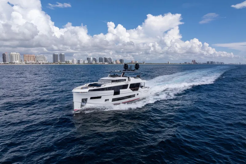  Yacht Photos Pics Luxurious 2021 Sirena 88 yacht cruising on open sea with city skyline backdrop.