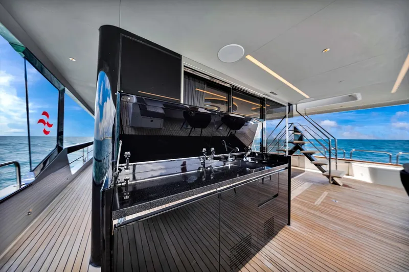  Yacht Photos Pics Luxurious Sirena 88 yacht deck with sleek outdoor kitchen, ocean view, and modern design.