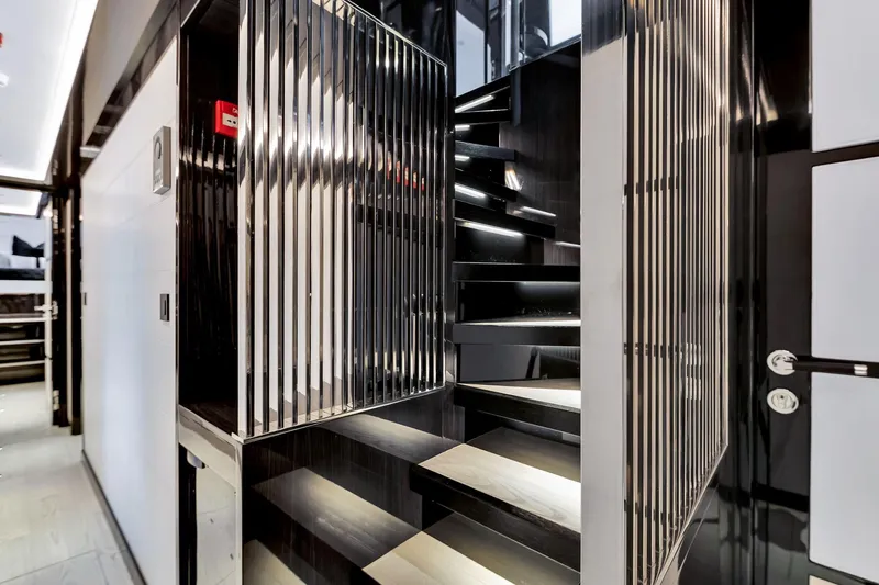  Yacht Photos Pics Modern interior staircase on a 2021 Sirena 88 yacht, featuring sleek black and metallic design.