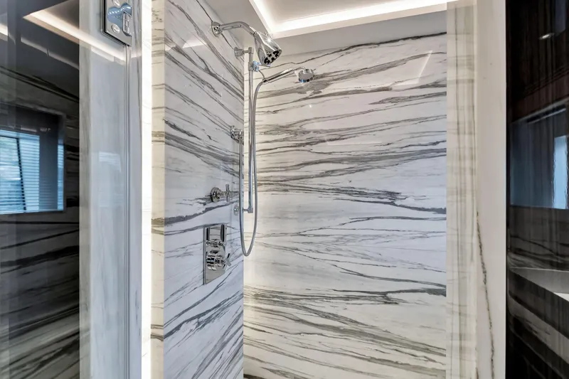  Yacht Photos Pics Luxurious marble shower in 2021 Sirena 88 yacht, featuring sleek chrome fixtures.